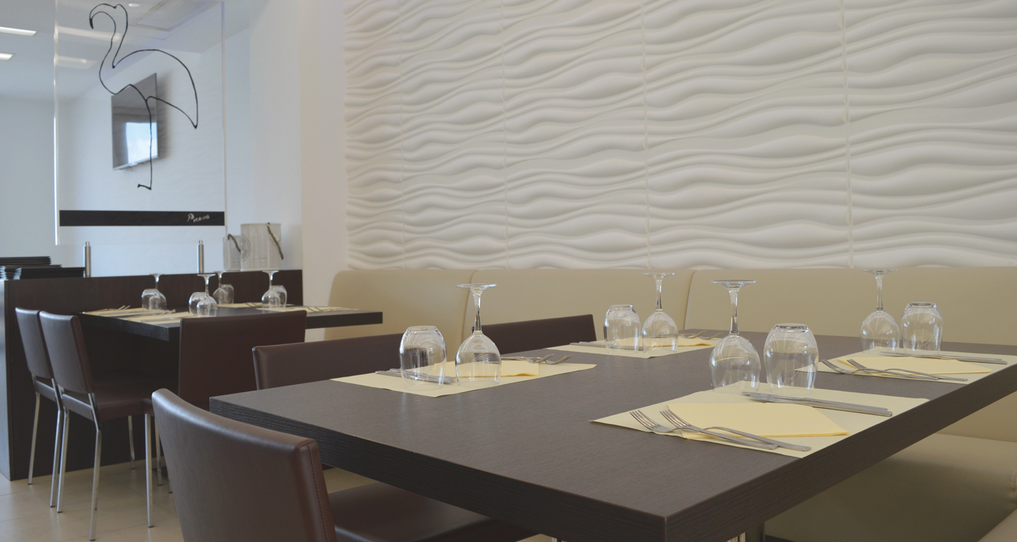 immagine in dettaglio del locale con tavoli ad angolo e mise en place