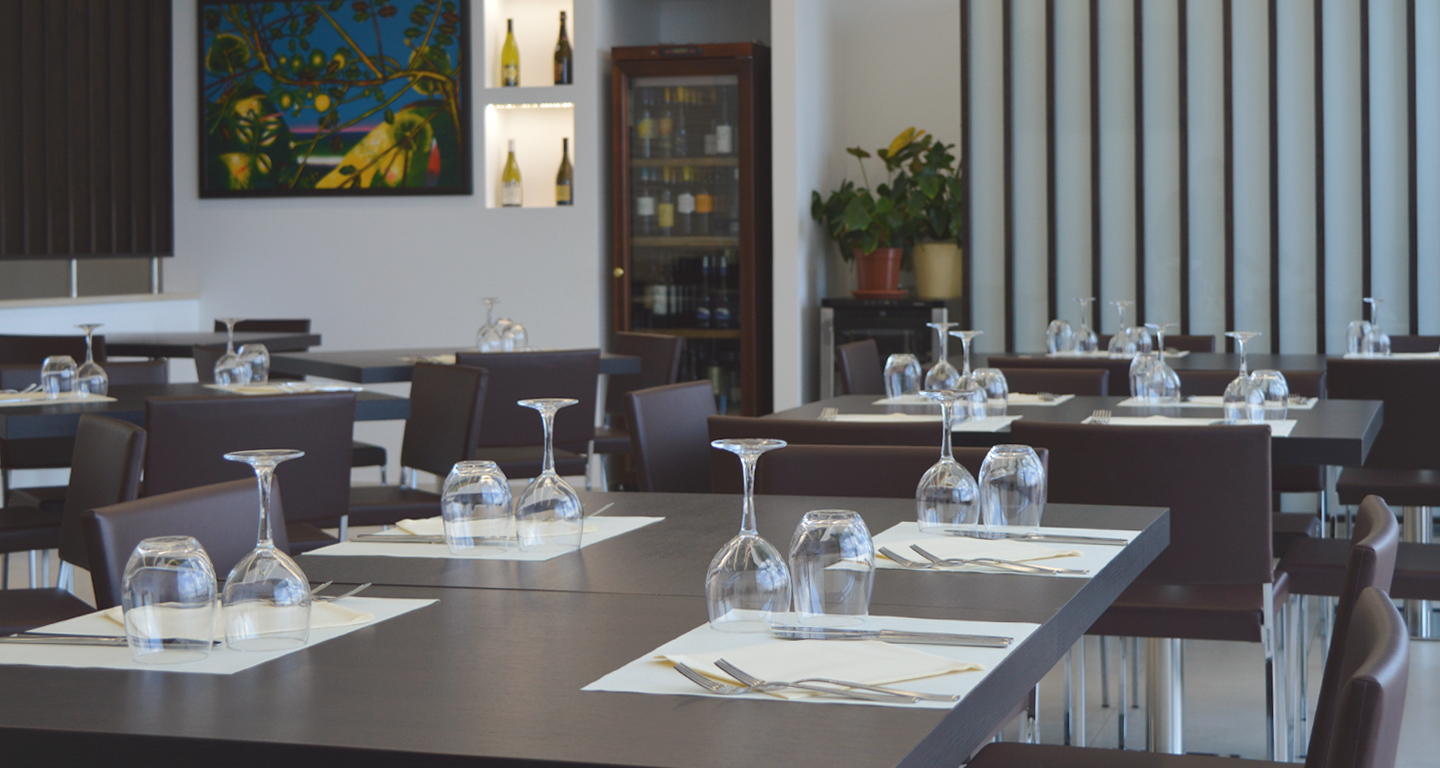 immagine in dettaglio del locale con tavoli e mise en place